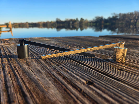 A picture of a black and gold candle snuffer.